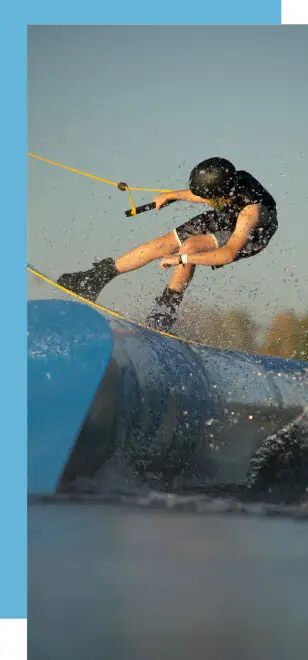 Wakeboarderin slides über ein Obstacle im Süsel Wakeboard Park