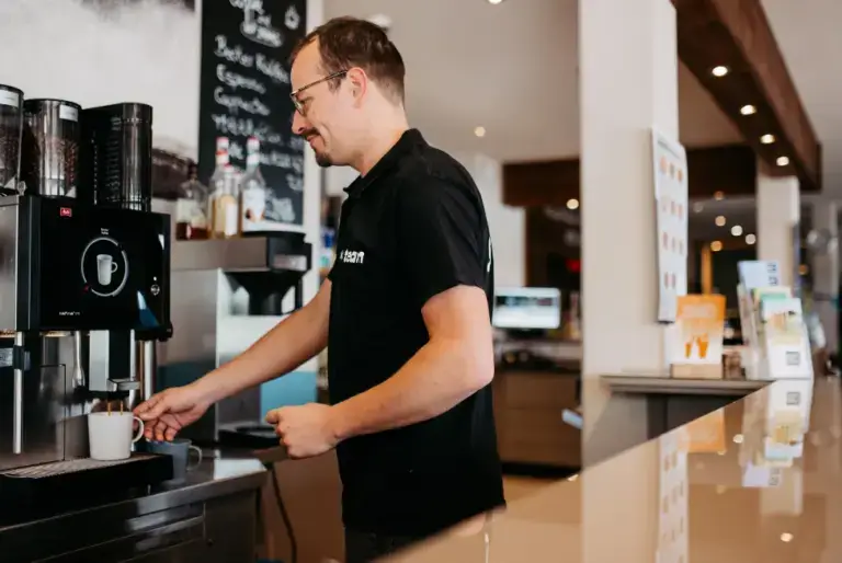 Süsel Seeparx Mitarbeiter hinter dem Tresen beim Kaffezubereiten