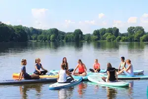 Stand Up Paddler auf dem See in Süsel Seeparx in einem Kreis dicht beieinander