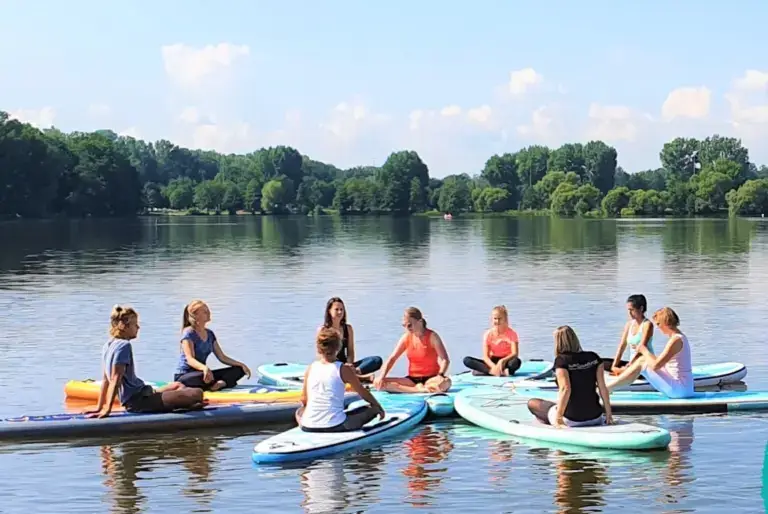 Stand Up Paddler auf dem See in Süsel Seeparx in einem Kreis dicht beieinander