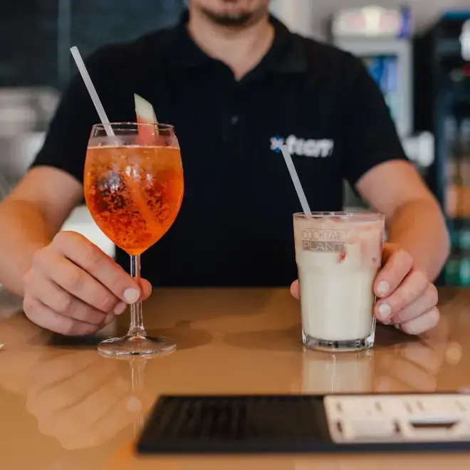 Mitarbeiter des Süsel Seeparx serviert einen Aperol Spritz und einen Eiskaffee