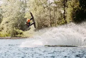 Wakeboarder im Sprung mit spritzendem Wasser in Süsel Seeparx