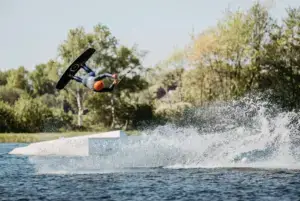 Wakeboarder im Sprung mit spritzendem Wasser in Süsel Seeparx