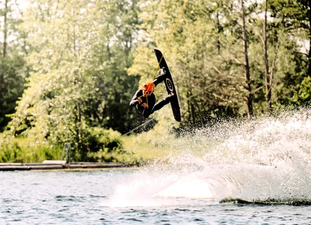 Wakeboarder im Sprung mit spritzendem Wasser in Süsel Seeparx