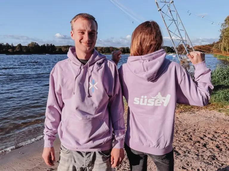 Zwei junge Leute mit neuem Hoodie in rosa mit Süsel Seeparx Logosignet und Süsel Schriftzug bedruckt