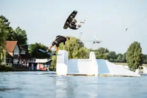 Zwei Wakeboarder im Sprung über ein Hindernis im Wakeboard Park in Süsel